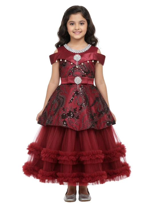 Young girl wearing a red and black embroidered dress on a white background