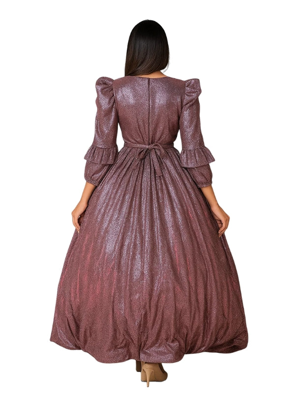 Woman wearing a long, patterned dress on a white background