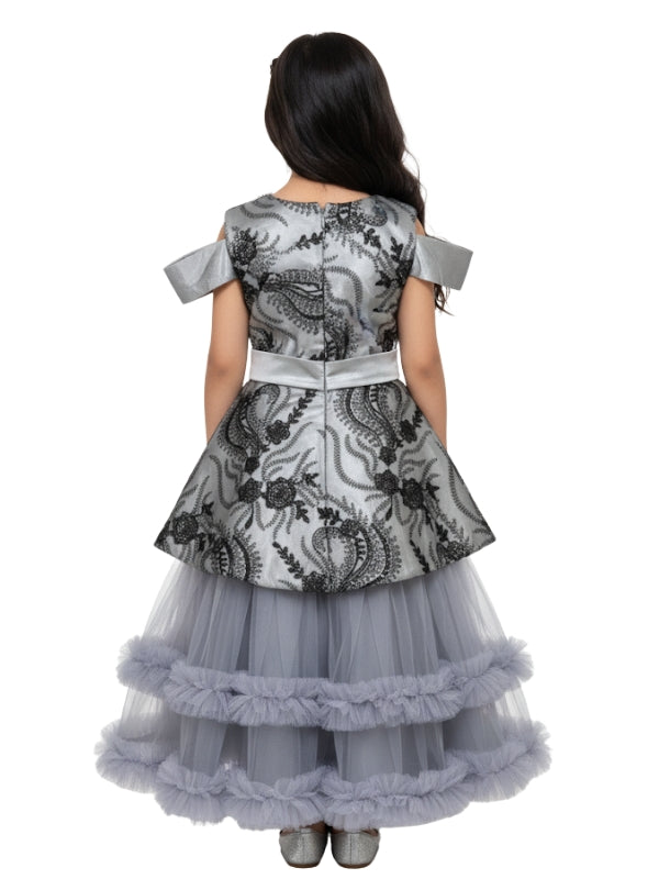 Girl wearing a gray and black floral dress with a layered skirt on a white background