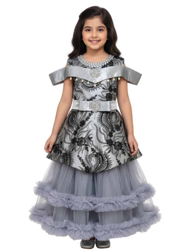 Young girl wearing a gray and black patterned dress with a white background