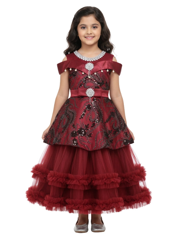 Young girl wearing a red and black embroidered dress on a white background