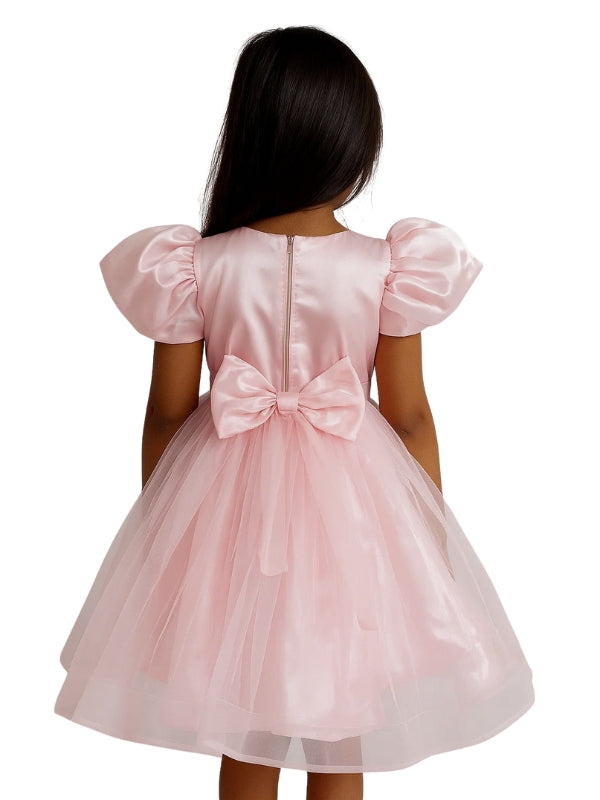 Pink dress with a bow on the back worn by a person, on a white background