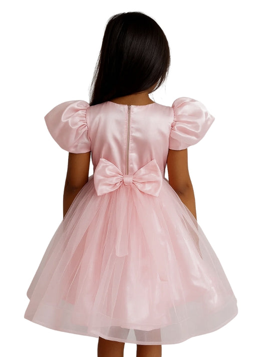 Pink dress with a bow on the back worn by a person, on a white background