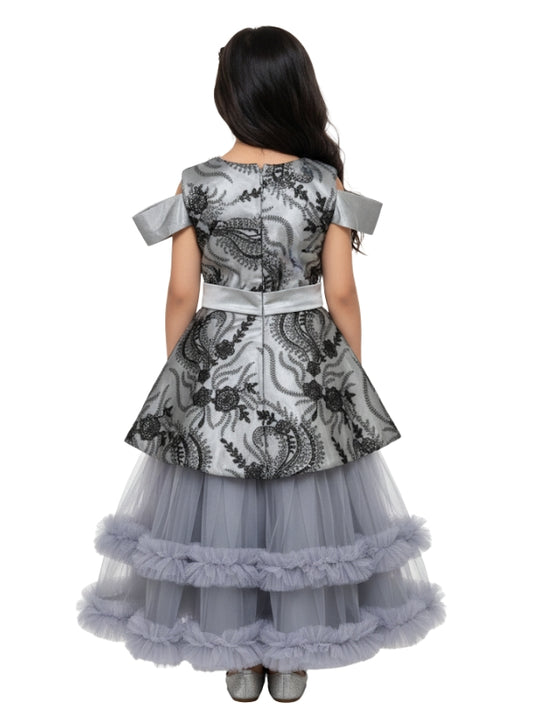 Girl wearing a gray and black floral dress with a layered skirt on a white background